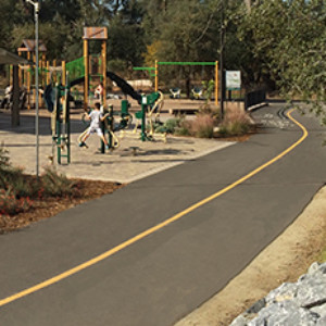 view of park with playground equipment and walking path